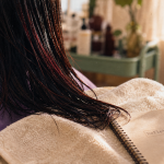 Reflet rouge sur cheveux noir, mèches acajou au salon